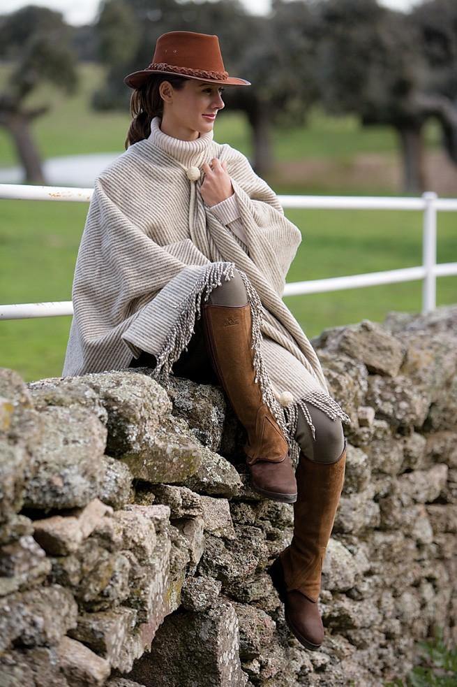 Cream fringed poncho, olive trousers, brown hat and suede boots